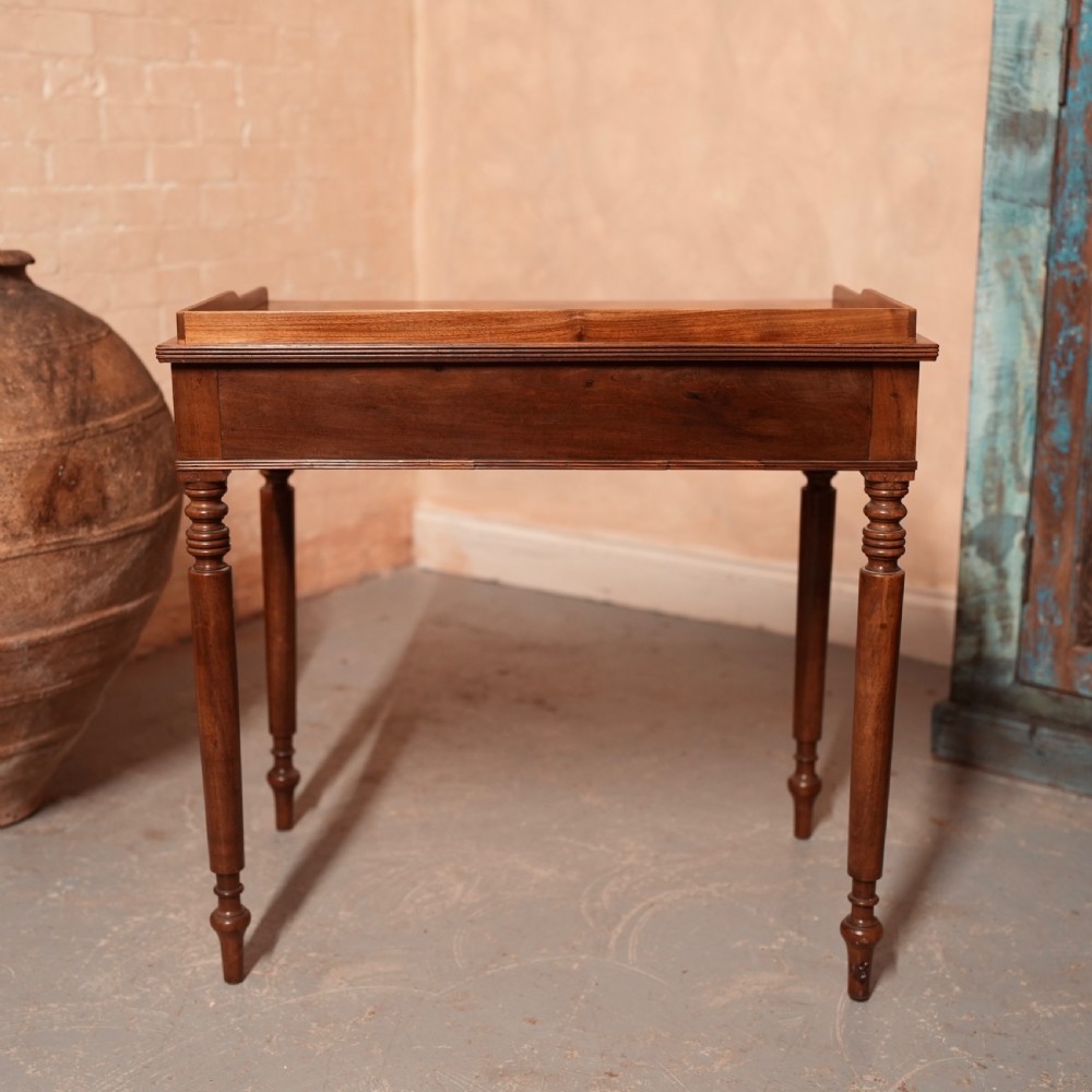 A Georgian mahogany writing table featuring a low gallery rim, two frieze drawers with turned wooden knobs, and slender turned legs. View XII