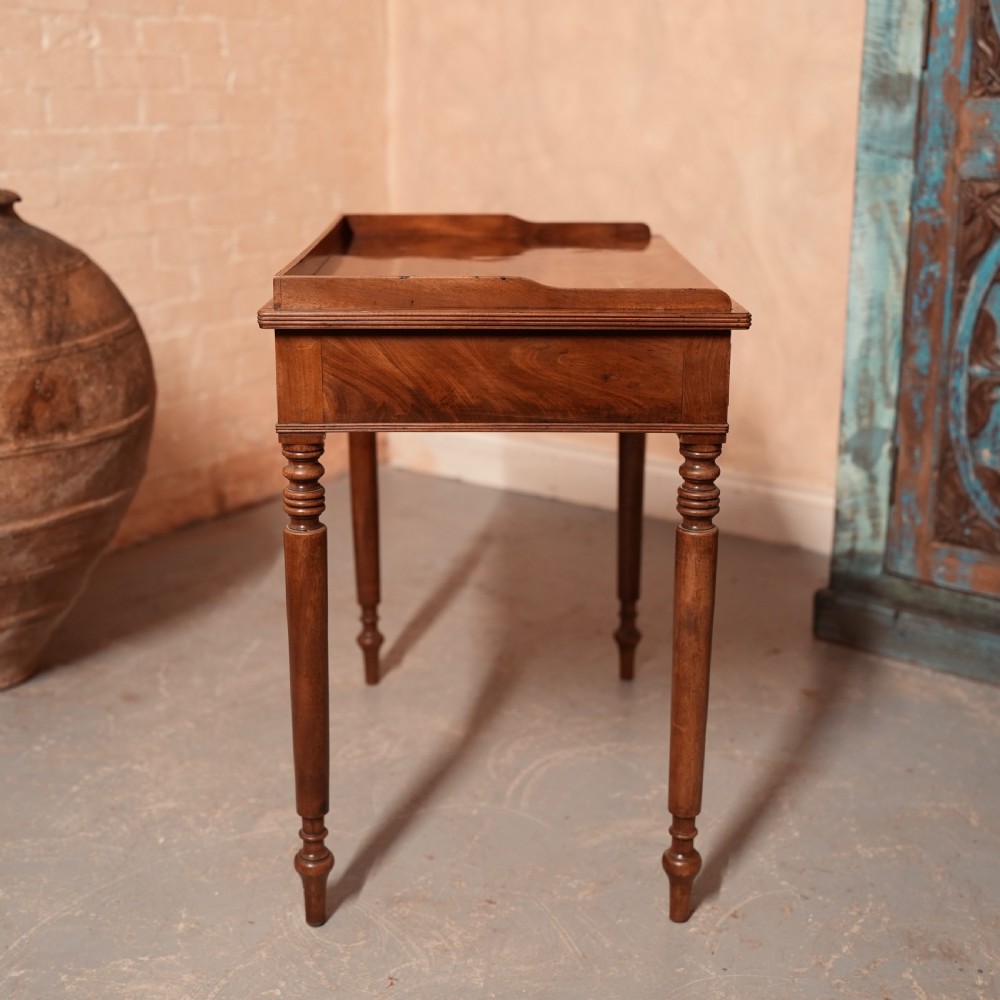 A Georgian mahogany writing table featuring a low gallery rim, two frieze drawers with turned wooden knobs, and slender turned legs. View XIII