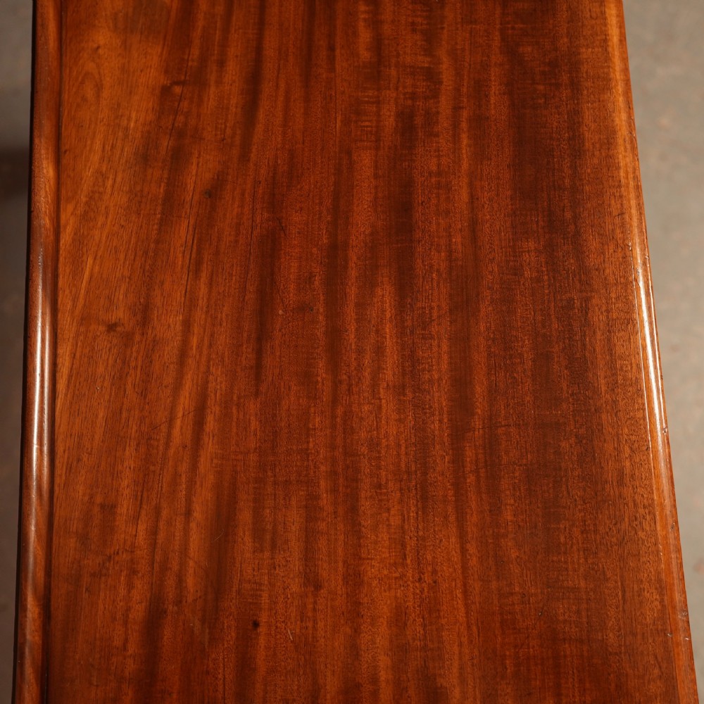 A William IV mahogany writing table featuring a raised gallery top, two frieze drawers with wooden knob handles, and reeded turned legs with brass castors. View VI