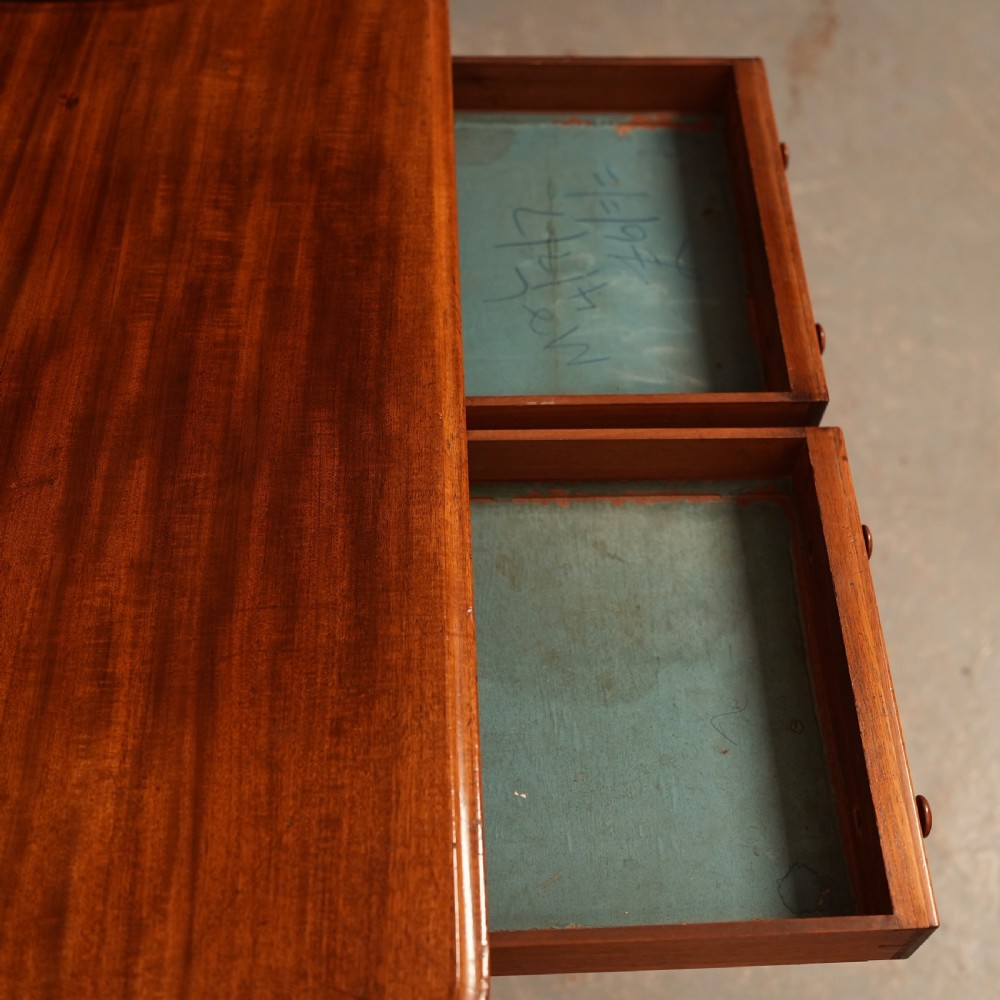 A William IV mahogany writing table featuring a raised gallery top, two frieze drawers with wooden knob handles, and reeded turned legs with brass castors. View VIII