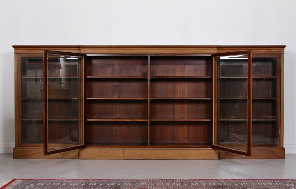 A low, wide Georgian mahogany breakfront bookcase featuring four glass doors and internal timber shelves. View II