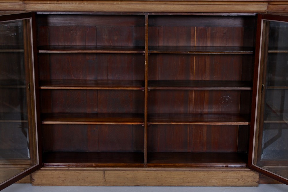 A low, wide Georgian mahogany breakfront bookcase featuring four glass doors and internal timber shelves. View IV
