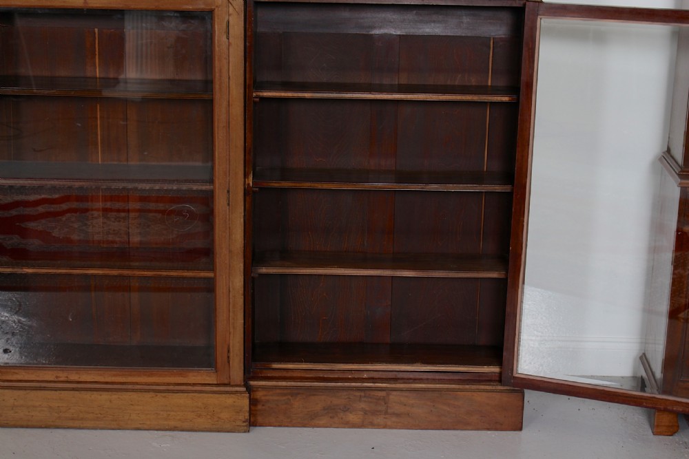 A low, wide Georgian mahogany breakfront bookcase featuring four glass doors and internal timber shelves. View VI