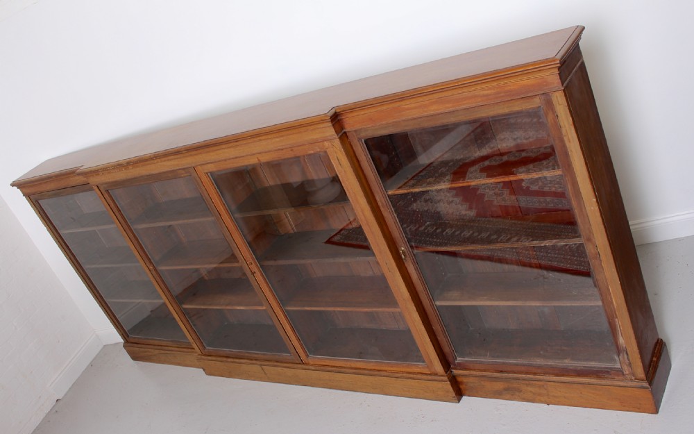 A low, wide Georgian mahogany breakfront bookcase featuring four glass doors and internal timber shelves. View XI