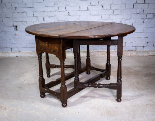 Early 18th Century English Oak Gate Leg Table with Central Drawer.