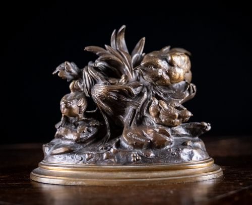 fig 1. A 19th-century dark patinated bronze sculpture depicting parent birds and fledglings surrounding a foliage nest on an oval base.