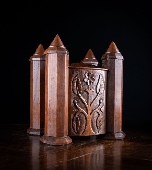 fig 1. A 19th-century carved oak jewellery box designed like a castle with four corner turrets, floral relief panels, and small drawers.