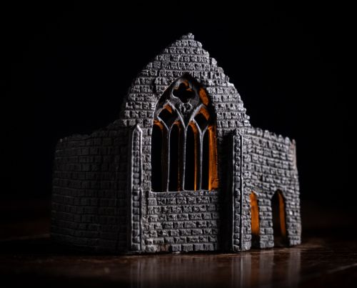 fig 1. A dark hand-carved bog oak miniature representing a Gothic abbey architectural ruin with a tracery window and relief masonry wall.