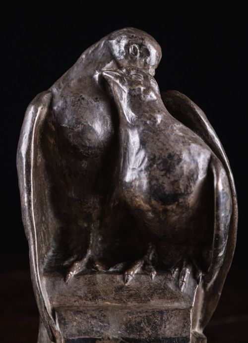 fig 1. A patinated nickel bronze sculpture depicting two pigeons embracing atop a geometric plinth.