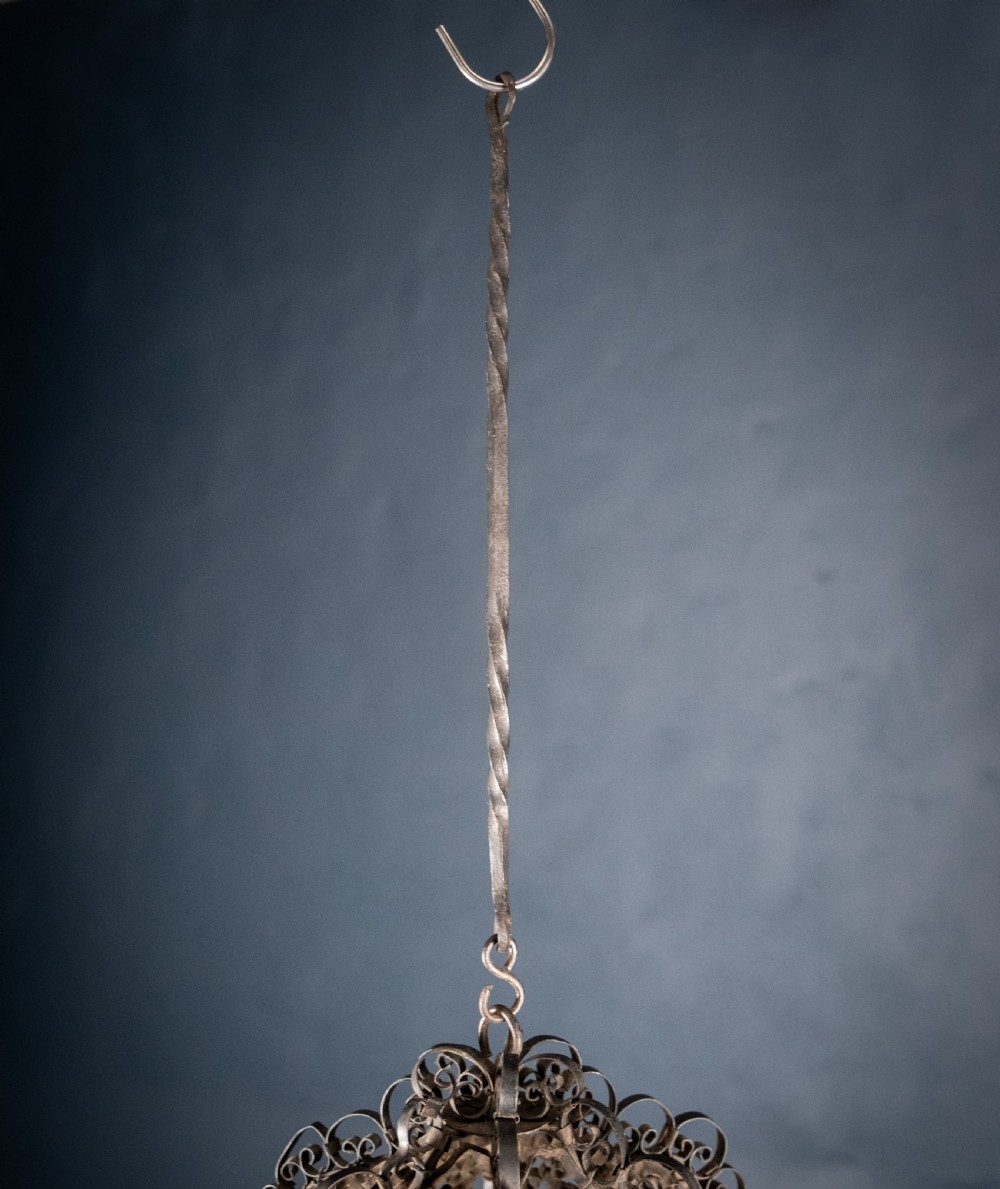 A 19th-century Venetian hanging lantern crafted from intricate wrought iron scrollwork with inset round coloured glass panels in green, blue, and amber. View XIII