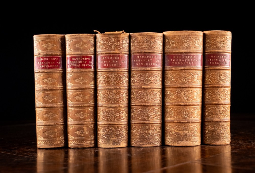 A set of six Victorian calf leather bound books standing vertically with gilt-tooled spines and crimson title labels.