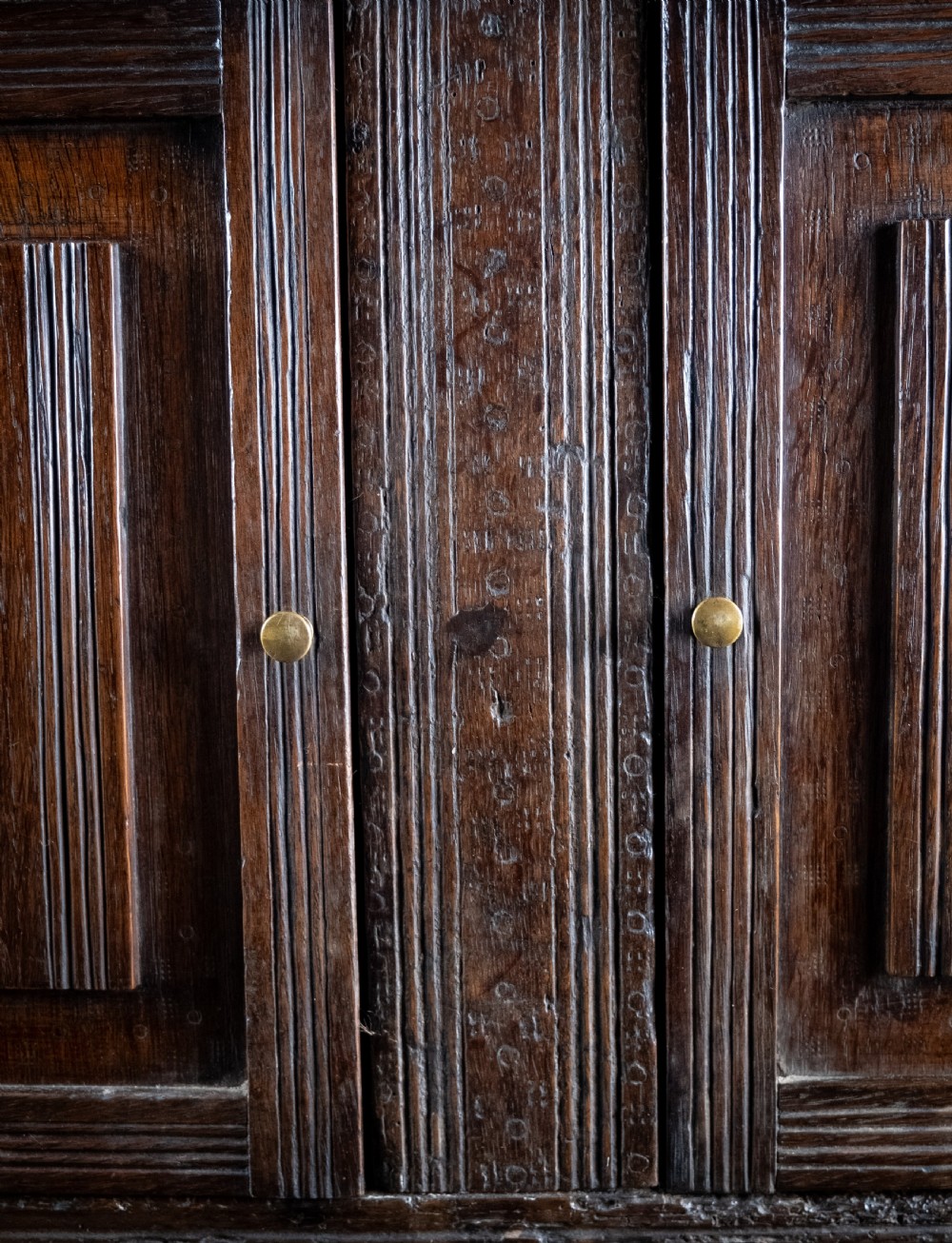 A rectangular eighteenth-century oak wall cupboard featuring double panelled doors, geometric mouldings, and turned corner columns. View II