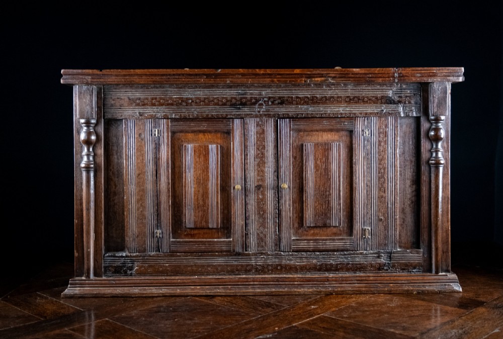 A rectangular eighteenth-century oak wall cupboard featuring double panelled doors, geometric mouldings, and turned corner columns. View III