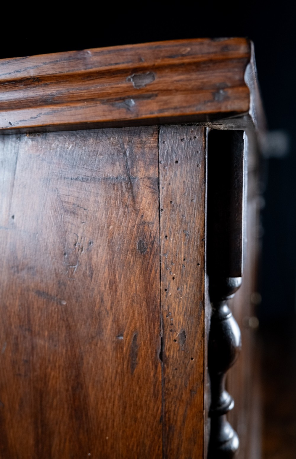 A rectangular eighteenth-century oak wall cupboard featuring double panelled doors, geometric mouldings, and turned corner columns. View XII