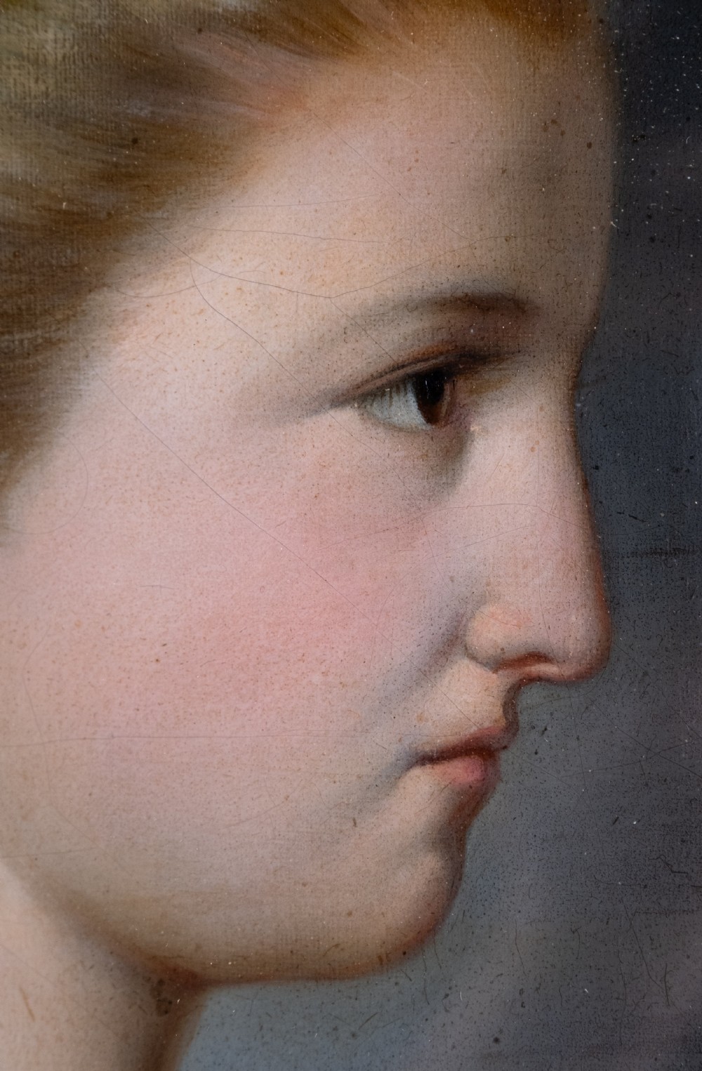 An oval 19th-century oil painting depicting the profile of a young girl wearing a blue dress and hair ribbon, enclosed in an ornate gold frame. View V