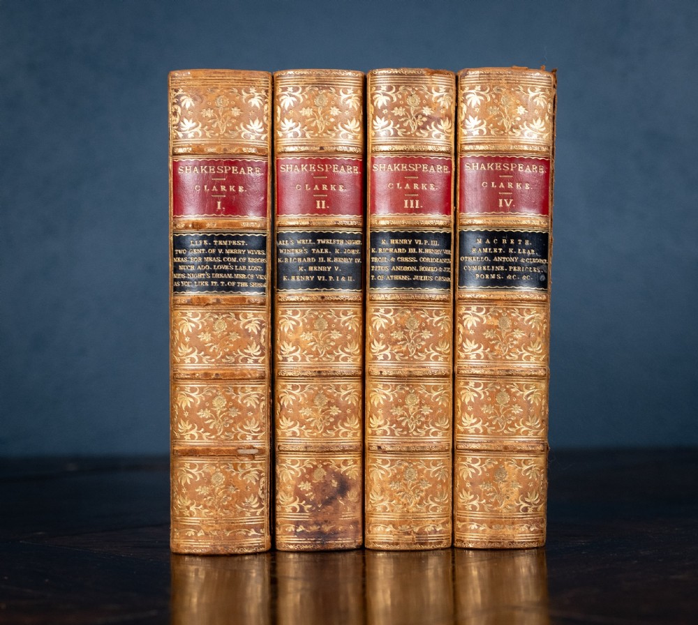 A four-volume set of 1881 Shakespeare leather-bound books standing upright, featuring heavily gilt-tooled spines with red and black title labels.