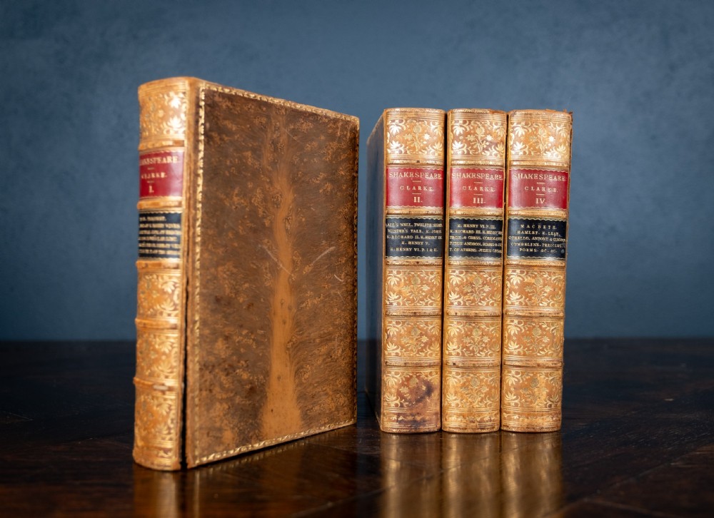 A four-volume set of 1881 Shakespeare leather-bound books standing upright, featuring heavily gilt-tooled spines with red and black title labels. View VI