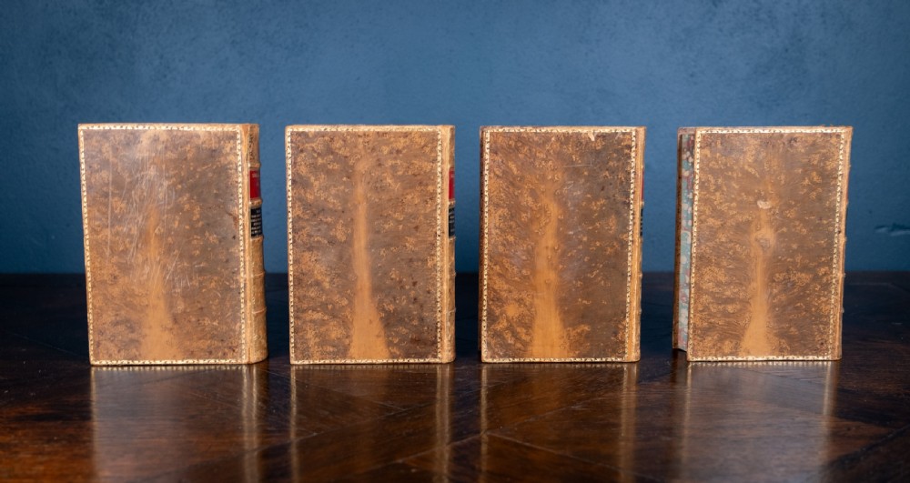 A four-volume set of 1881 Shakespeare leather-bound books standing upright, featuring heavily gilt-tooled spines with red and black title labels. View IX
