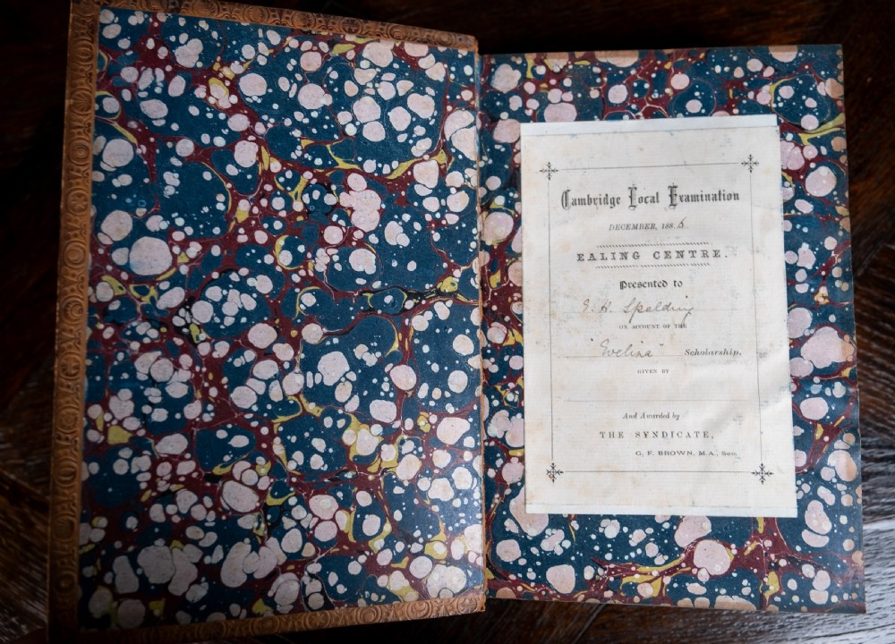 A four-volume set of 1881 Shakespeare leather-bound books standing upright, featuring heavily gilt-tooled spines with red and black title labels. View X