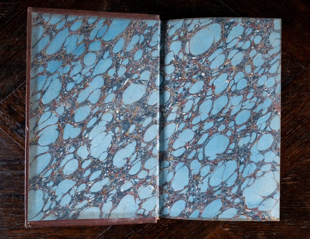 A 1850 Victorian leather-bound book featuring gold gilt floral tooling on the spine and a black title label. View VI