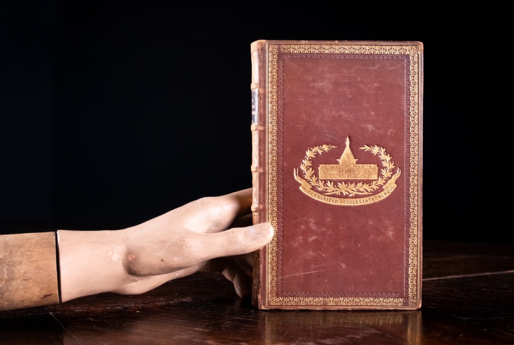 A 1850 Victorian leather-bound book featuring gold gilt floral tooling on the spine and a black title label. View XII