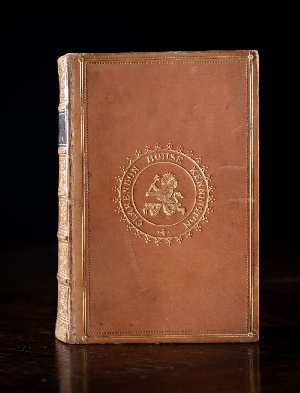 An 1857 tan leather-bound book titled Nineveh and Its Palaces featuring a gilded spine with raised bands and blind-tooled decoration. View II