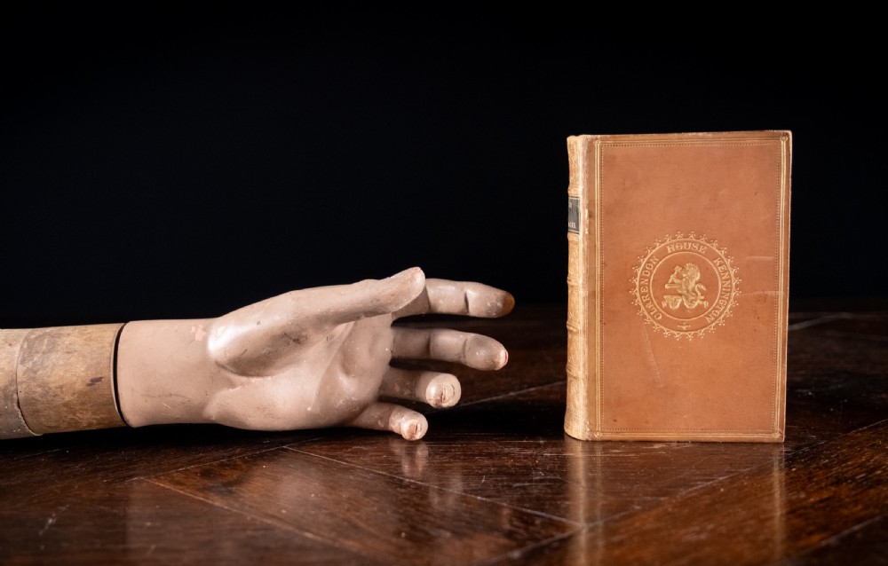 An 1857 tan leather-bound book titled Nineveh and Its Palaces featuring a gilded spine with raised bands and blind-tooled decoration. View VII