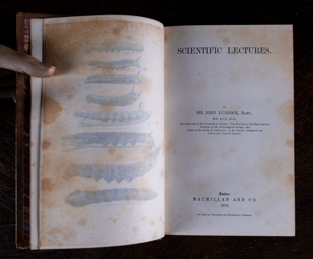 A nineteenth-century tan leather-bound book featuring ornate gilt tooling on the spine and an embossed coat of arms on the front cover. View VII