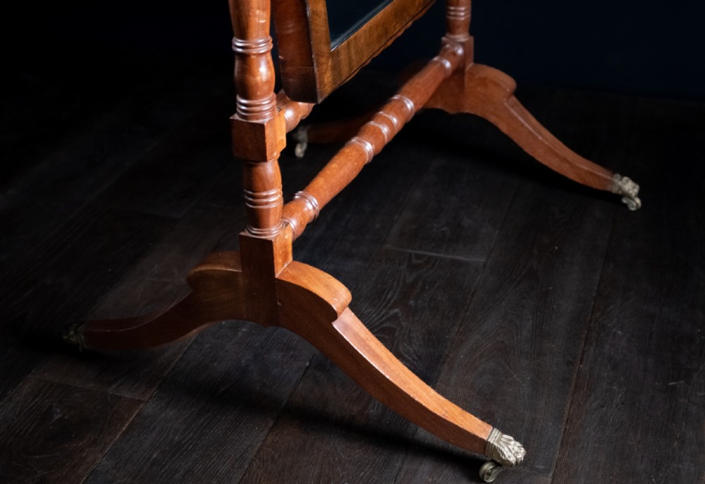 A full-length 19th-century mahogany cheval mirror featuring a rectangular swivelling glass plate within a turned wooden frame supported by splayed legs with brass castors. View II