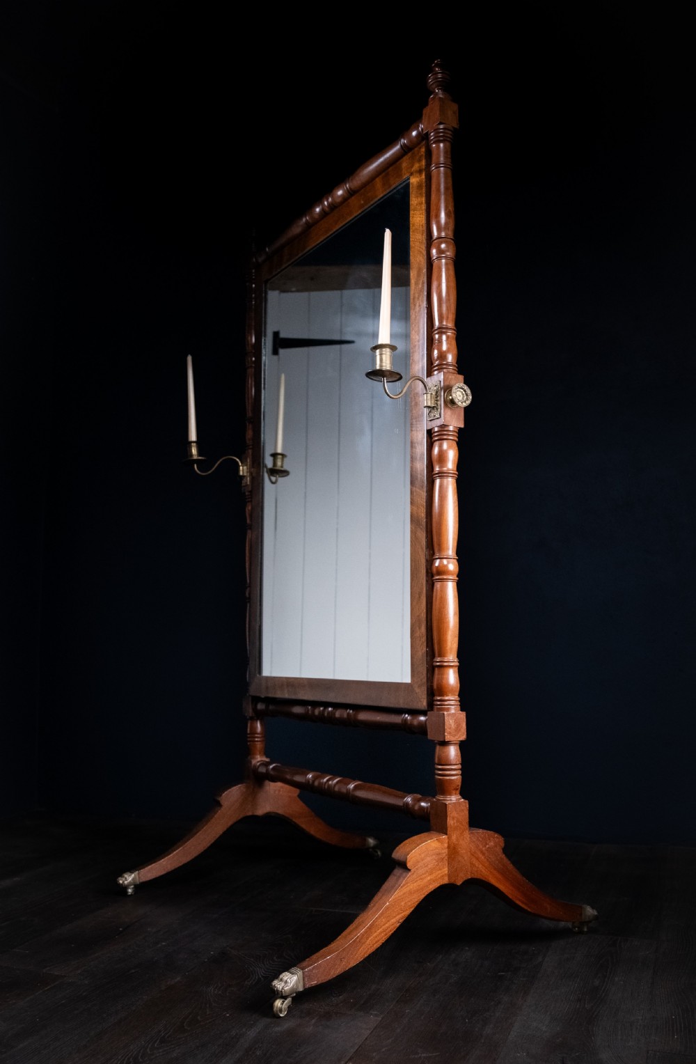 A full-length 19th-century mahogany cheval mirror featuring a rectangular swivelling glass plate within a turned wooden frame supported by splayed legs with brass castors. View III
