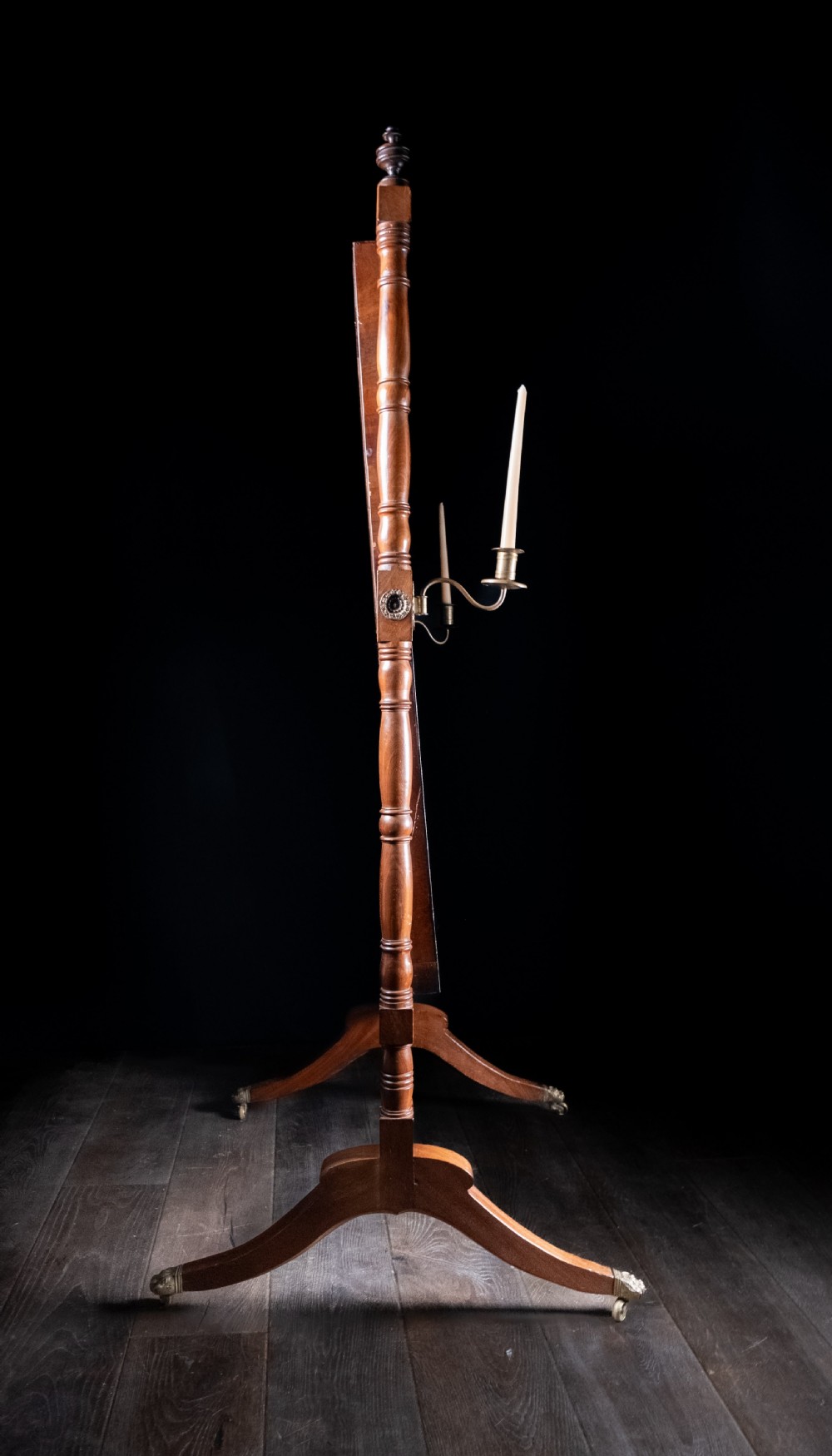 A full-length 19th-century mahogany cheval mirror featuring a rectangular swivelling glass plate within a turned wooden frame supported by splayed legs with brass castors. View VII