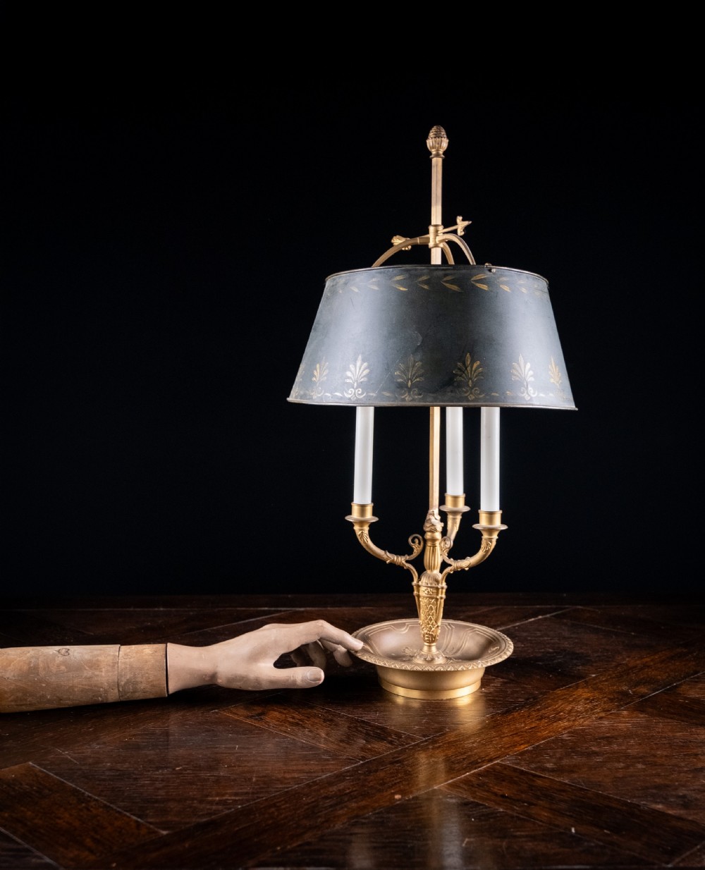 A gilt brass bouillotte lamp featuring a dark adjustable shade and three candle-style lights on a circular tray base. View II