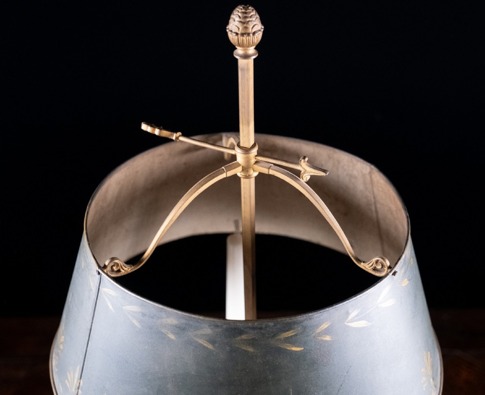 A gilt brass bouillotte lamp featuring a dark adjustable shade and three candle-style lights on a circular tray base. View X