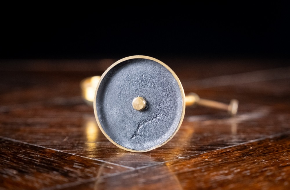 A lacquered brass bullseye condenser magnifying glass featuring an adjustable stand and a convex lens, positioned on a dark wooden surface. View VI