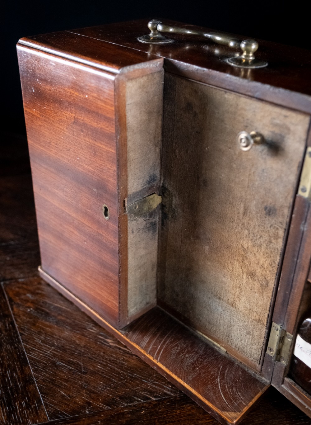 An open antique wooden apothecary cabinet featuring multiple compartments filled with vintage glass medicine bottles. View XV