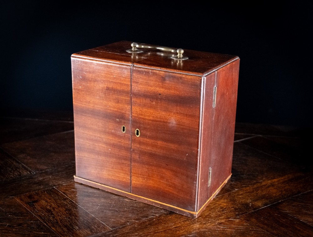 An open antique wooden apothecary cabinet featuring multiple compartments filled with vintage glass medicine bottles. View XVI