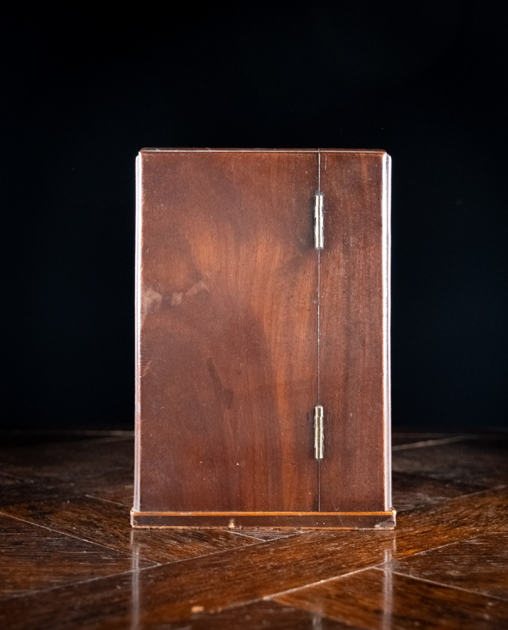 An open antique wooden apothecary cabinet featuring multiple compartments filled with vintage glass medicine bottles. View XXI