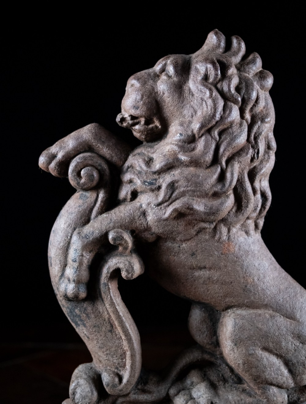 A nineteenth-century cast iron doorstop featuring a detailed rampant lion leaning against a scroll motif on a moulded plinth base. View II