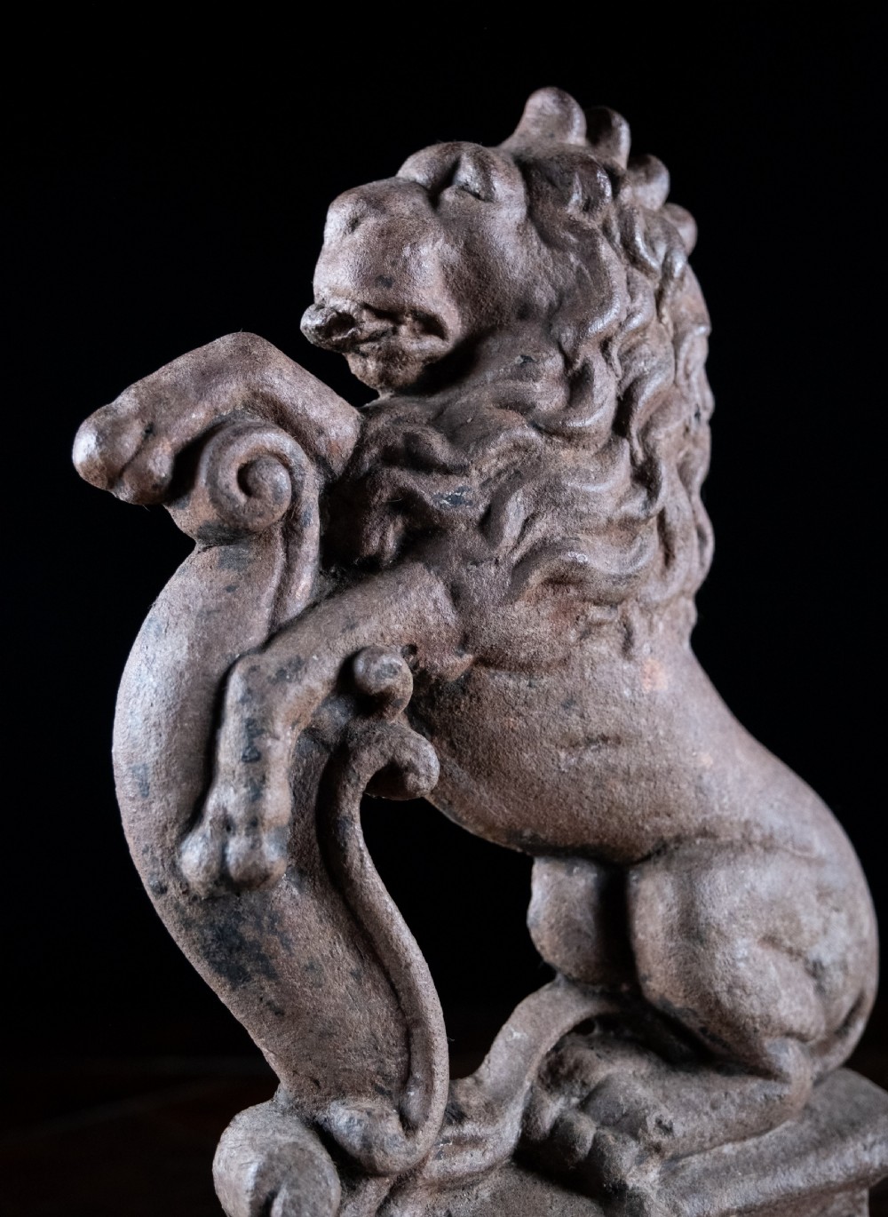 A nineteenth-century cast iron doorstop featuring a detailed rampant lion leaning against a scroll motif on a moulded plinth base. View III