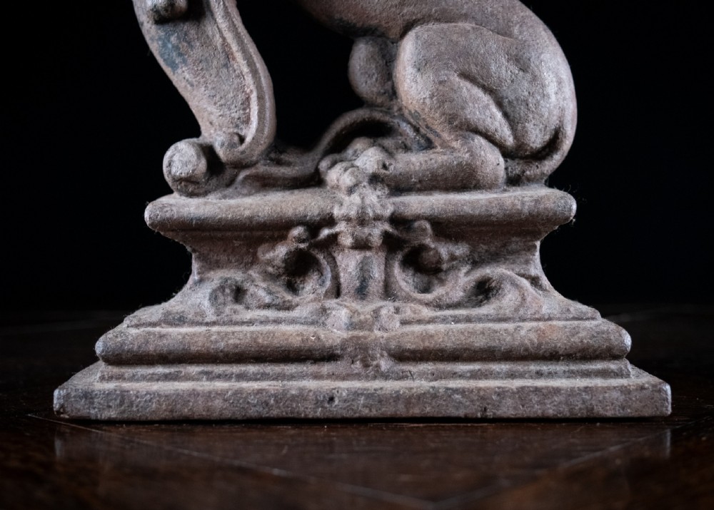 A nineteenth-century cast iron doorstop featuring a detailed rampant lion leaning against a scroll motif on a moulded plinth base. View IV
