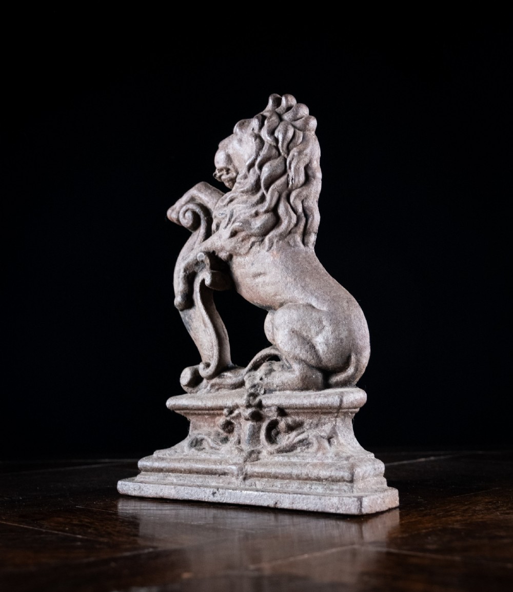A nineteenth-century cast iron doorstop featuring a detailed rampant lion leaning against a scroll motif on a moulded plinth base. View VI