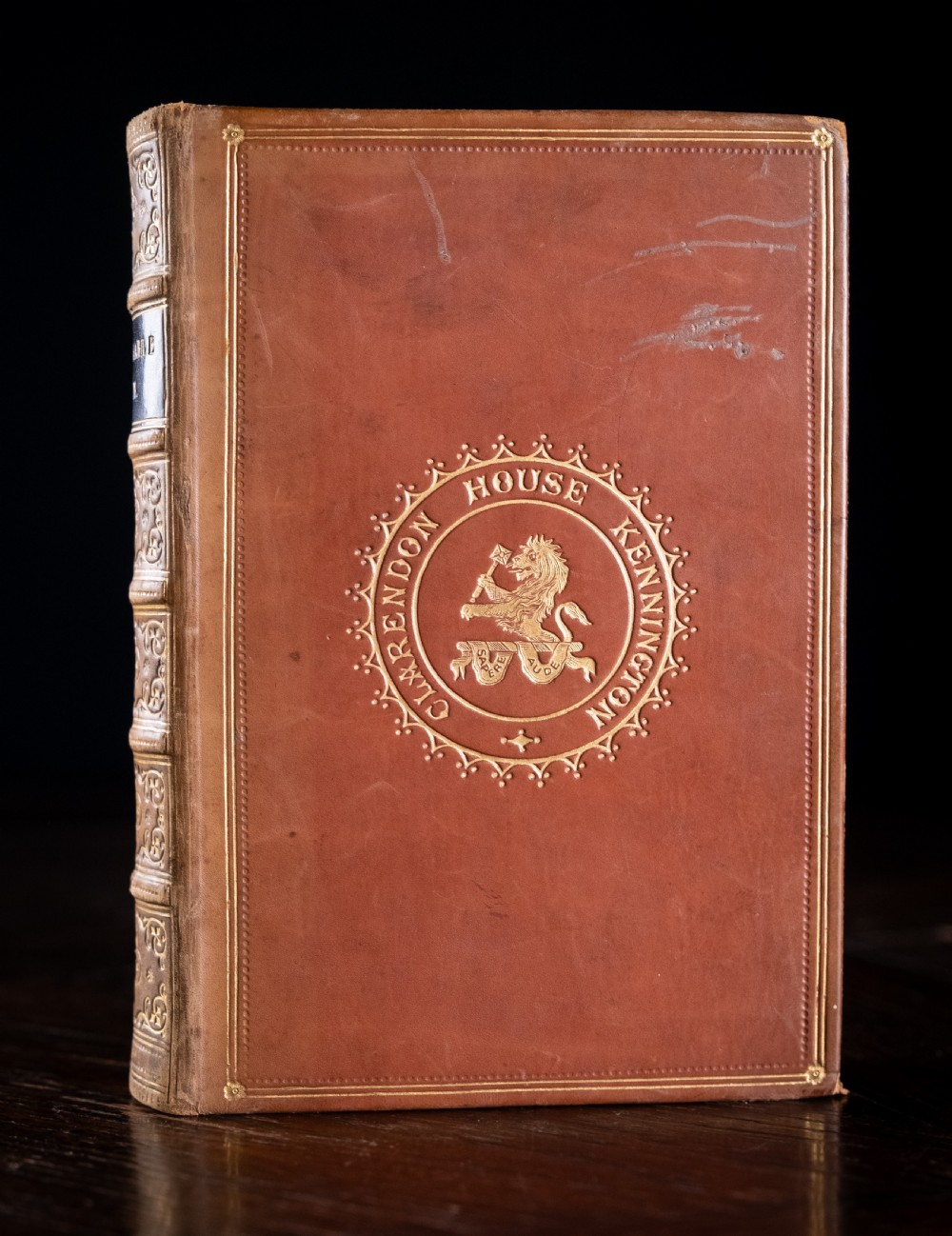 A Victorian tan leather-bound book titled Remarkable Men standing upright with ornate gold tooling on the spine and cover. View II