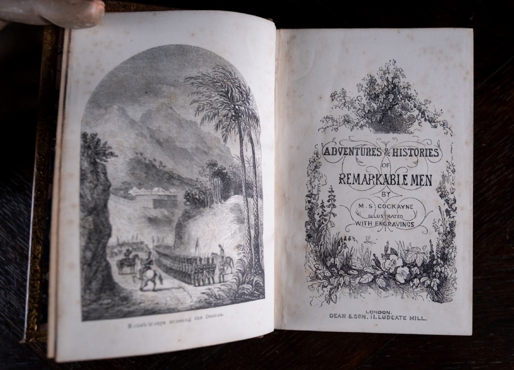 A Victorian tan leather-bound book titled Remarkable Men standing upright with ornate gold tooling on the spine and cover. View VII