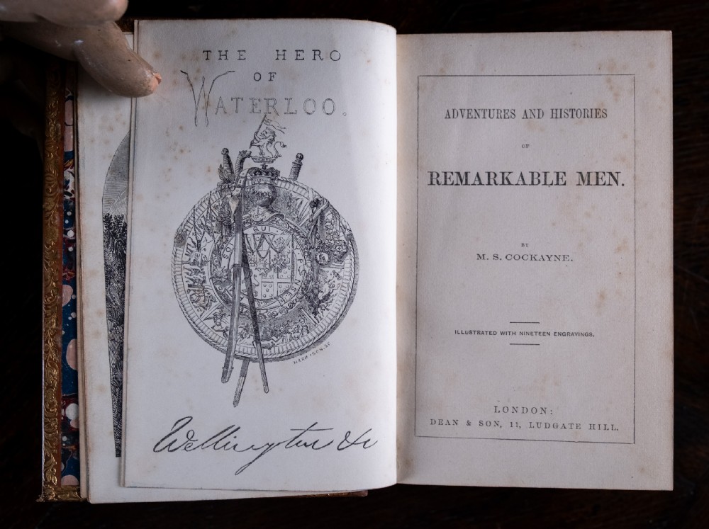 A Victorian tan leather-bound book titled Remarkable Men standing upright with ornate gold tooling on the spine and cover. View VIII
