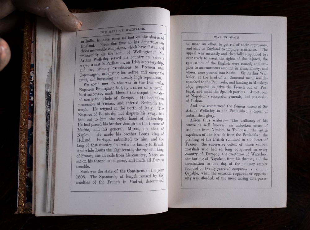A Victorian tan leather-bound book titled Remarkable Men standing upright with ornate gold tooling on the spine and cover. View IX