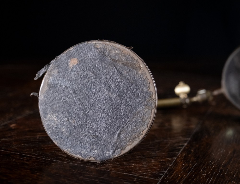 An antique Edwardian brass magnifying glass featuring an adjustable articulated arm and a circular weighted base. View X