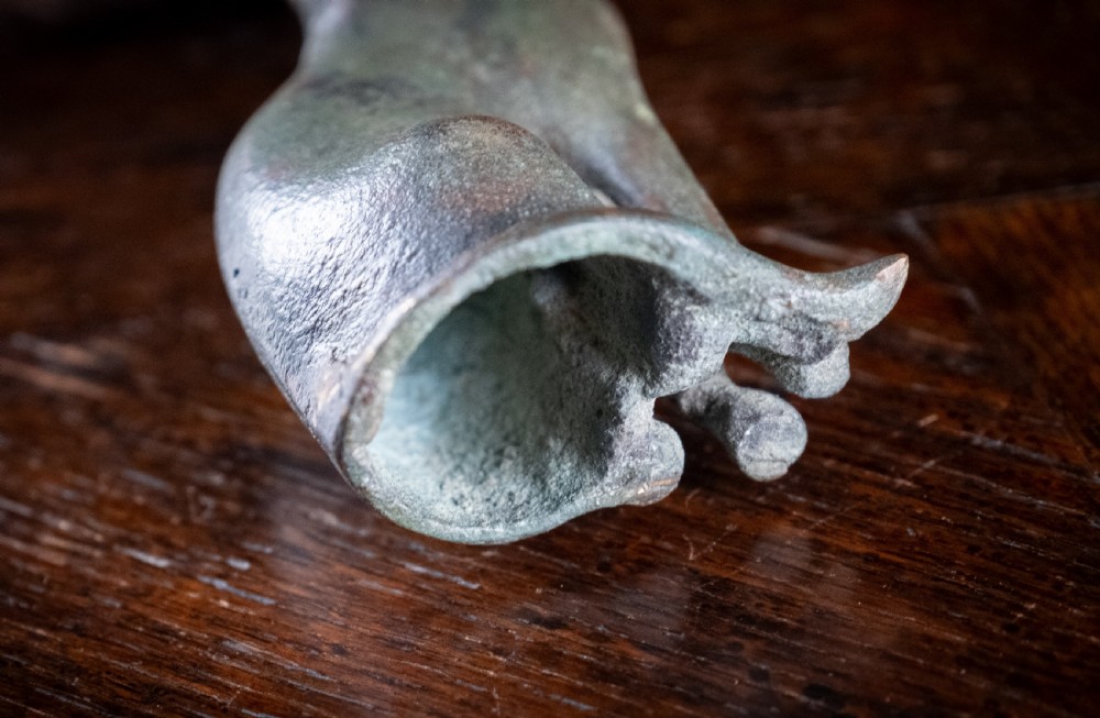 A dark patinated bronze figure of a seated Egyptian cat mounted on a wooden rectangular base. View IX