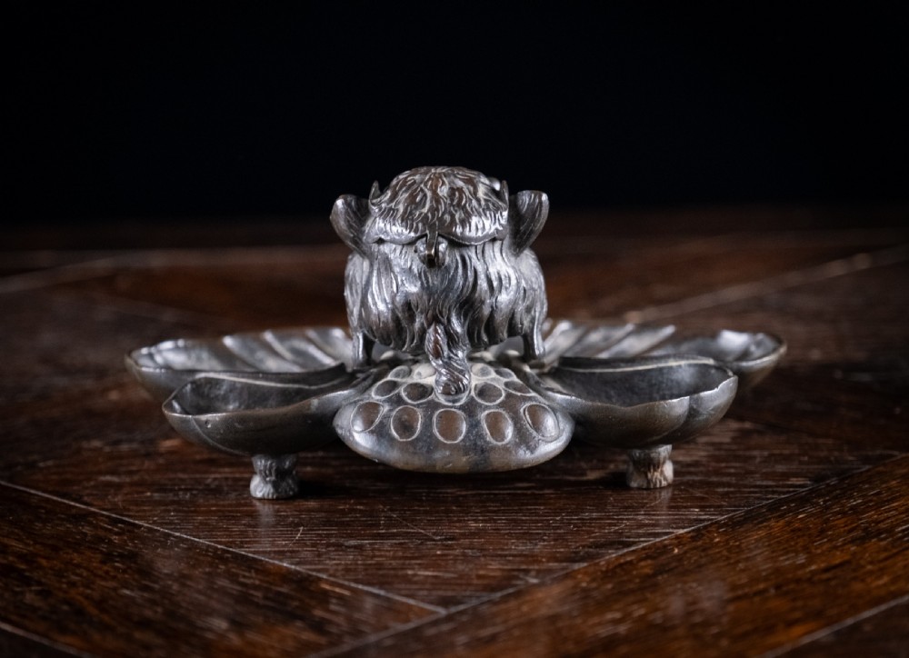 A 19th-century patinated bronze inkstand featuring a central sculpted grotesque face above a fluted pen tray raised on small paw feet. View VII