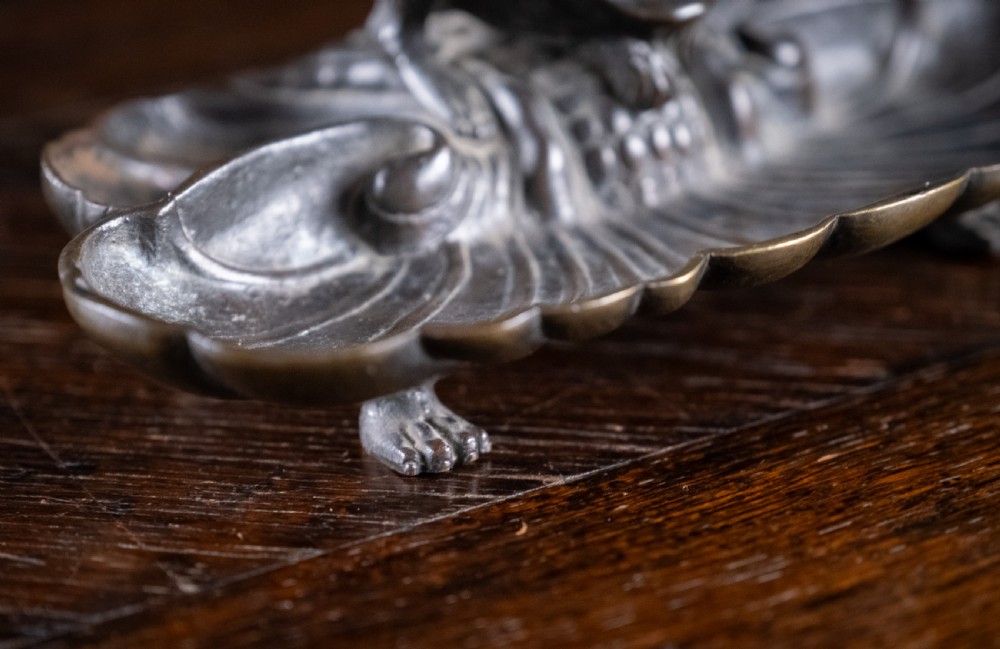 A 19th-century patinated bronze inkstand featuring a central sculpted grotesque face above a fluted pen tray raised on small paw feet. View IX