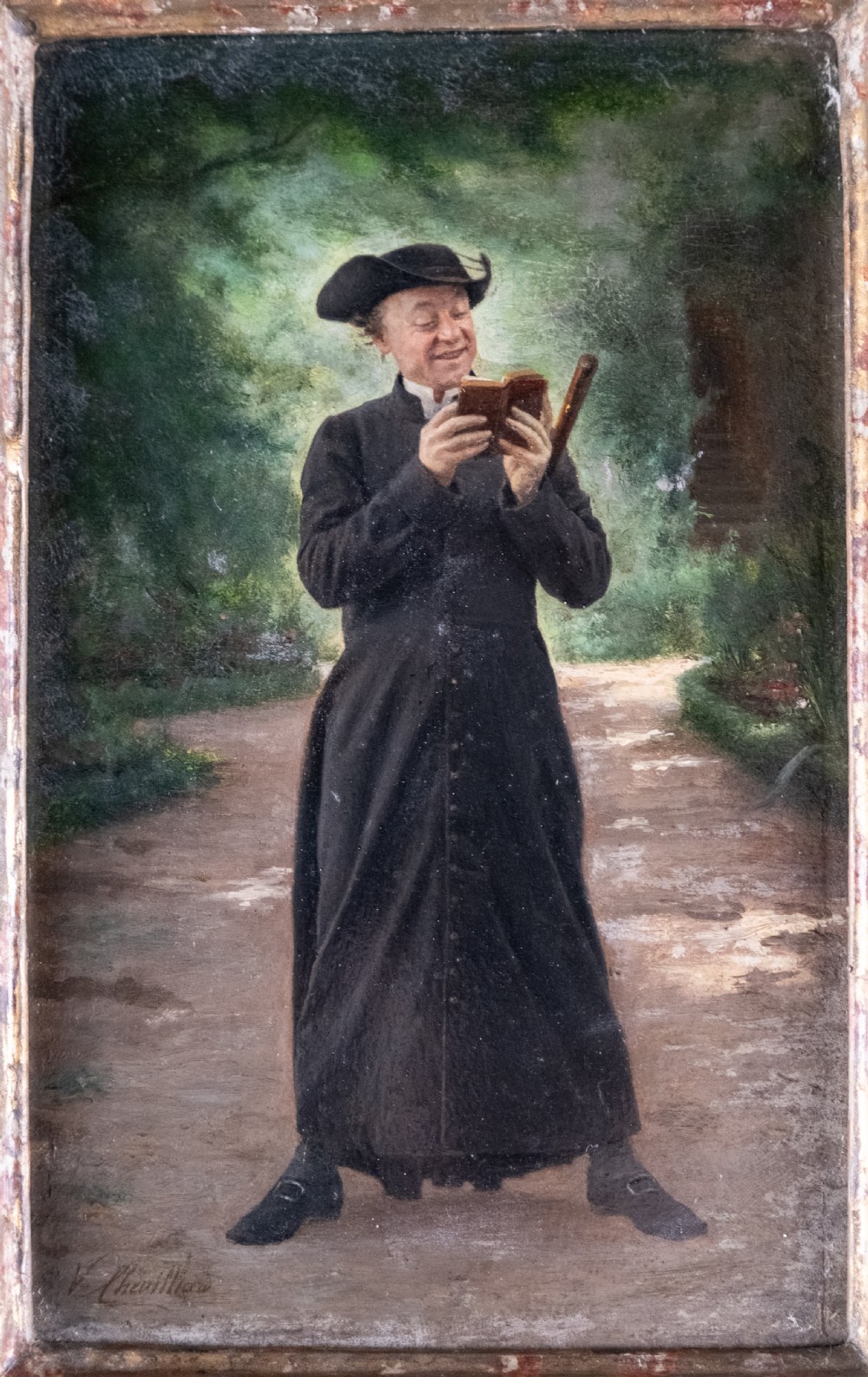 A 19th-century oil painting on panel depicting a smiling clergyman reading a book, set within a heavily carved rococo gilt frame. View III